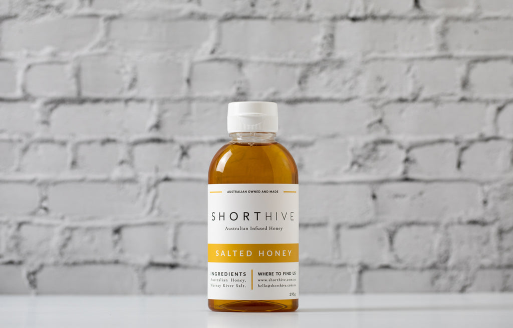 ShortHive Salted (caramel) Infused Australian Honey bottle. Up-close of bottle on white background. ShortHive Salted honey infused with Murray River Salt.