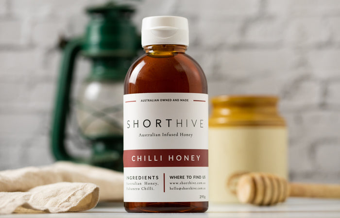 ShortHive Chilli (Spicy) Habanero Infused Australian Honey bottle. Up-close of bottle with styled background out of focus.