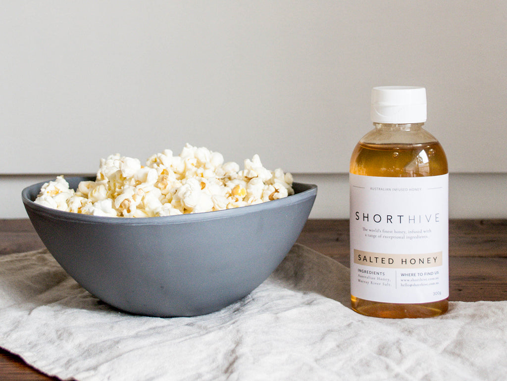 ShortHive Australian Caramel Salted Honey bottle pictured with a bowl of popcorn as a recipe pairing idea.