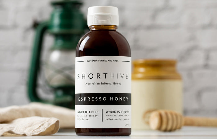 ShortHive Espresso (Coffee) Infused Australian Honey bottle. Up-close of bottle with styled background out of focus