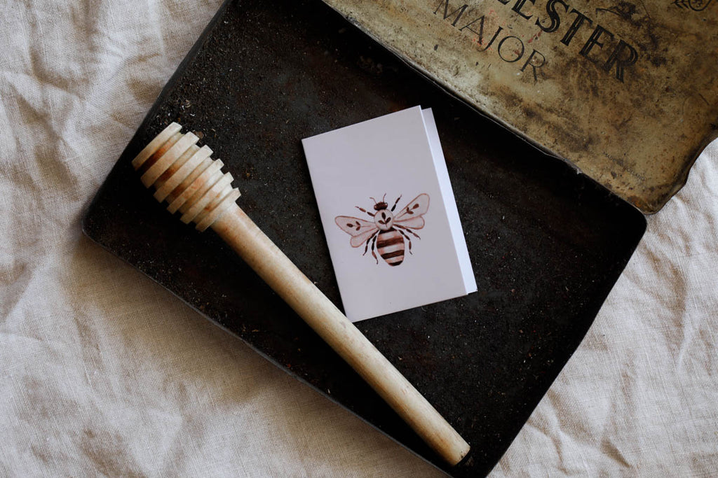 Styled image of bee gift tag and honey dipper